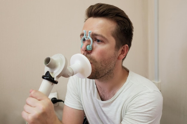 Photo young man testing breathing function by spirometry