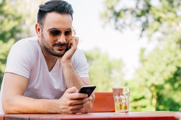 Young man texting in the cafe