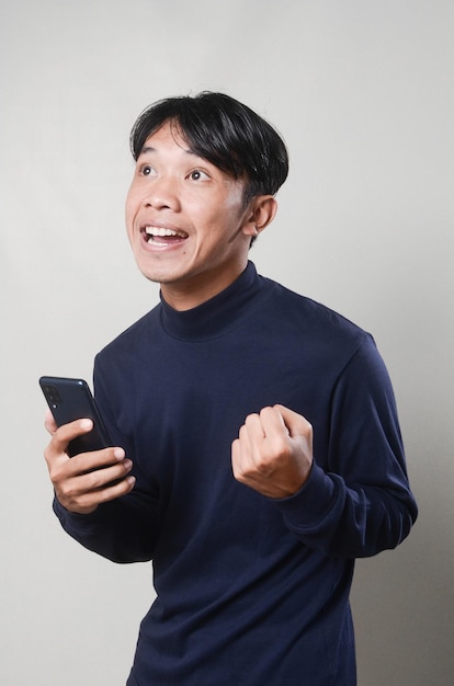 Young Man Texting Reading Chatting on His Phone Surprised Happy