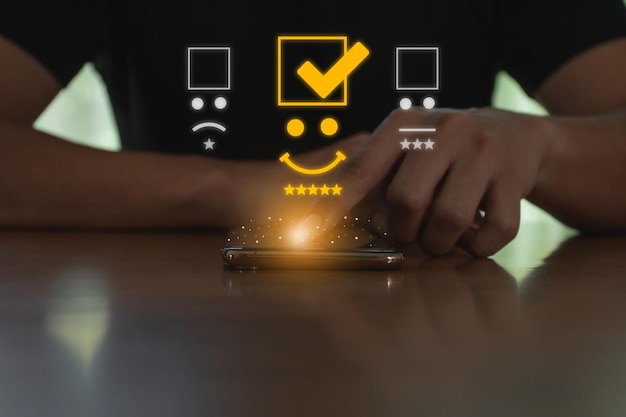 Young man touching the virtual screen on smartphone and press the five star icon to give satisfaction in service Demonstrates that customer satisfaction is essential to a successful business