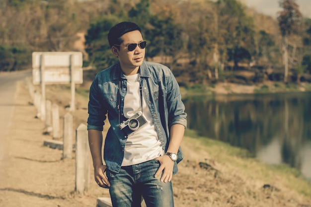 Young man tourist  standing and taking photos with vintage camera.