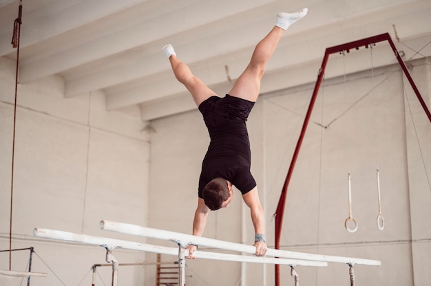 Young man training on parallel bars