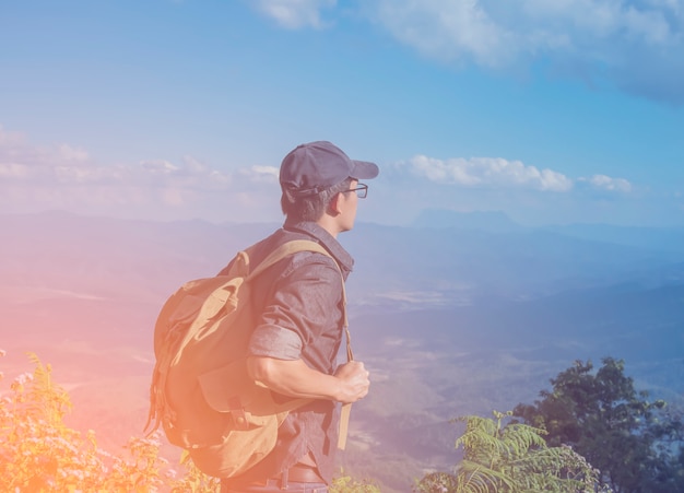 Young Man Traveler with map backpack relaxing outdoor with rocky mountains on background Summer vacations and Lifestyle hiking concept