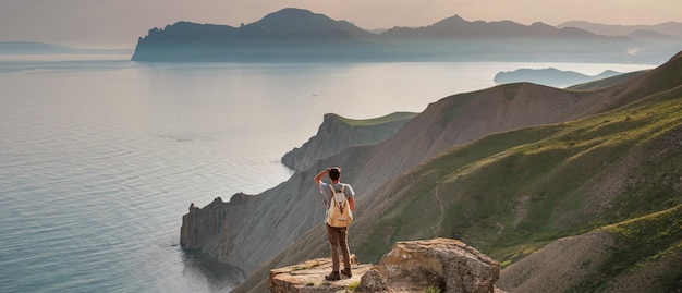 Young man travels alone on the backdrop of the mountains