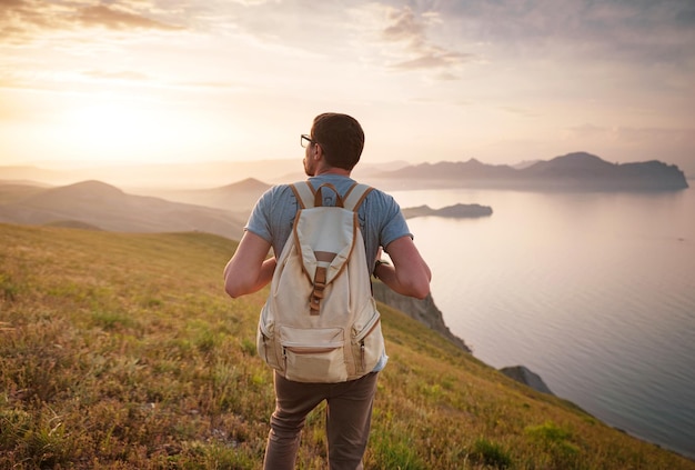 Young man travels alone on the backdrop of the mountains