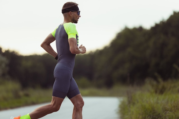 Young man, triathlon male athlete taking part at sport competition outdoors