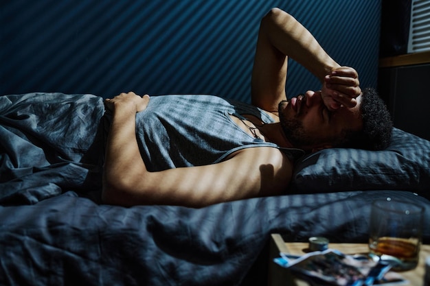 Young man in trouble staying up all night unable to get asleep