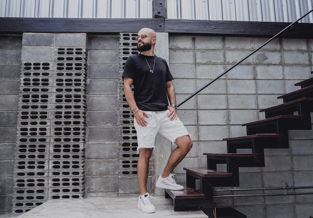 A young man in tshirt and shorts on the stairs at city streets