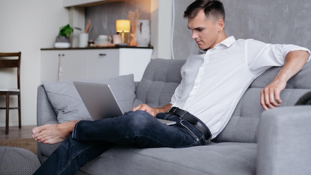 Young man using his laptop in a cozy living room