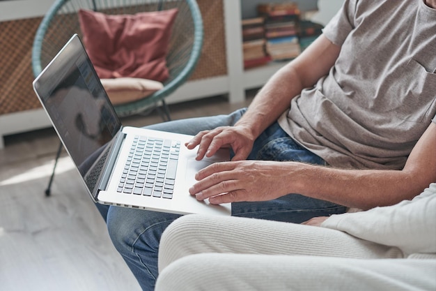 Young man using laptop and smiling at home