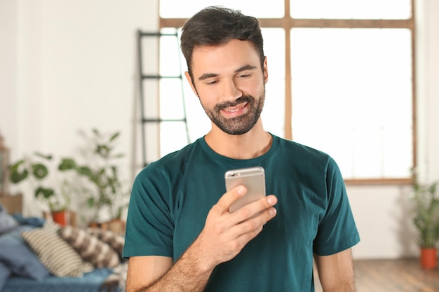 Young man using mobile phone indoors