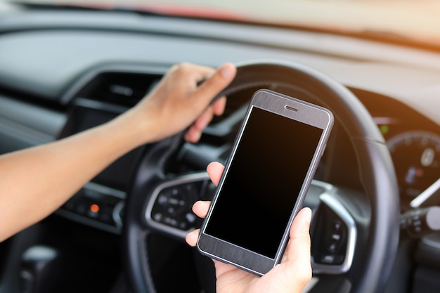 Young  man using phone while driving the car