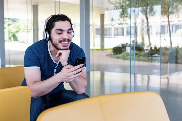 Young man using a smart phone at lobby