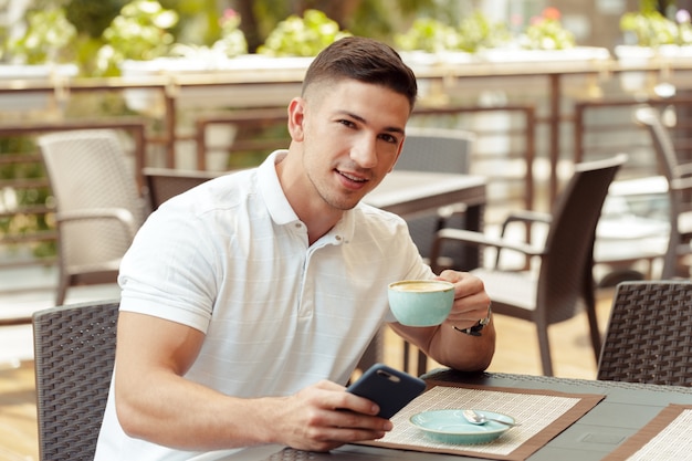 Young man using smartphone in cafe