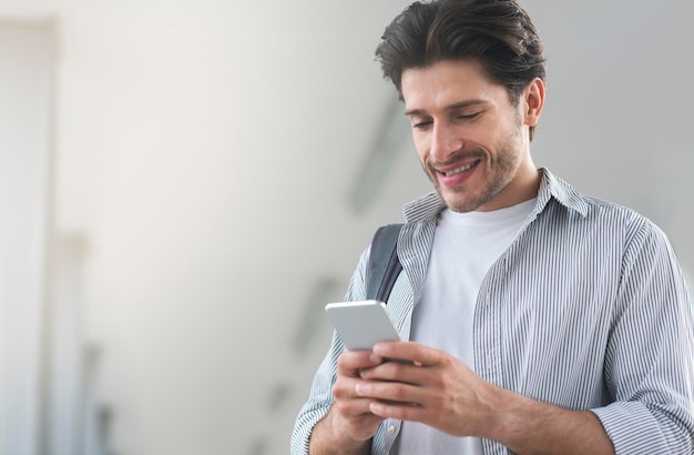 Young Man Using Smartphone While Waiting For His Flight In Airport