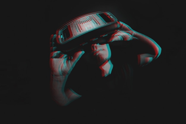 Young man using virtual reality headset VR. education online, studying concept. Black and white with 3D glitch virtual reality effect