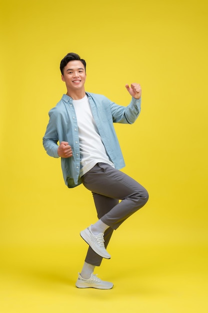 Young man very happy and excited doing winner gesture with arms raised