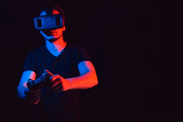 A young man in virtual reality glasses playing video games