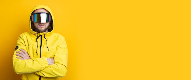 Young man in virtual reality glasses in a yellow jacket on a yellow background Banner