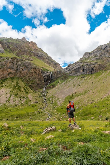 A young man visiting the Salto de Tendenera Waterfall in the Pyrenees in the Ripera Valley Huesca