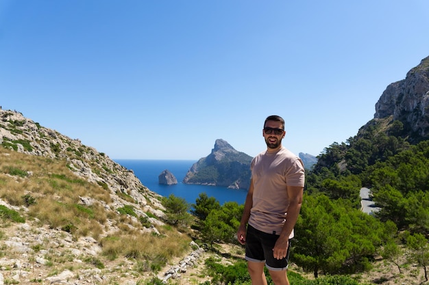 Young man visiting the viewpoint es Colomer in Mallorca Spain