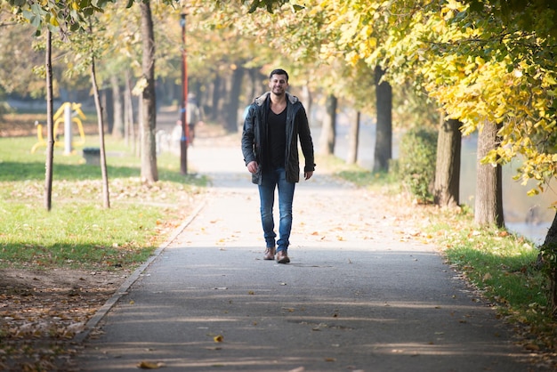 Young Man Walking In Forest Through The Woods Outside During Autumn