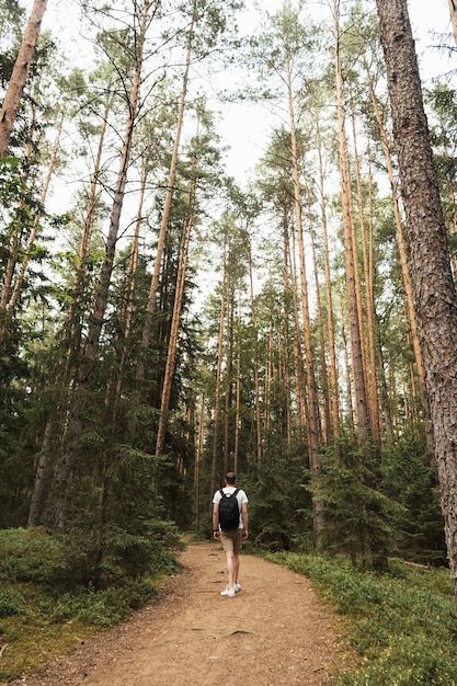 Young man walking in forest.