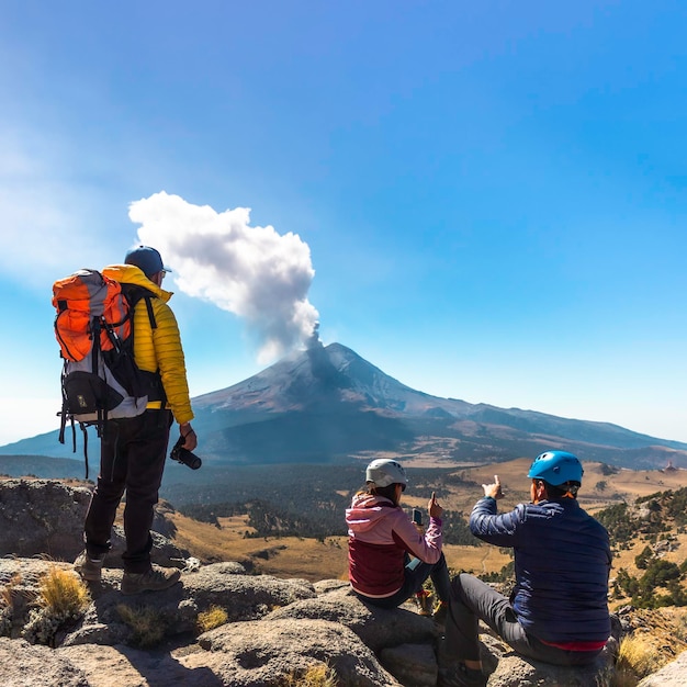 Young man walking on the mountain iztaccihuatl at dawn in the background the popocatepetl volcano