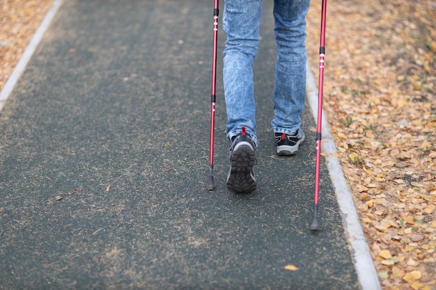 Young man walks with Scandinavian walking sticks Healthy lifestyle