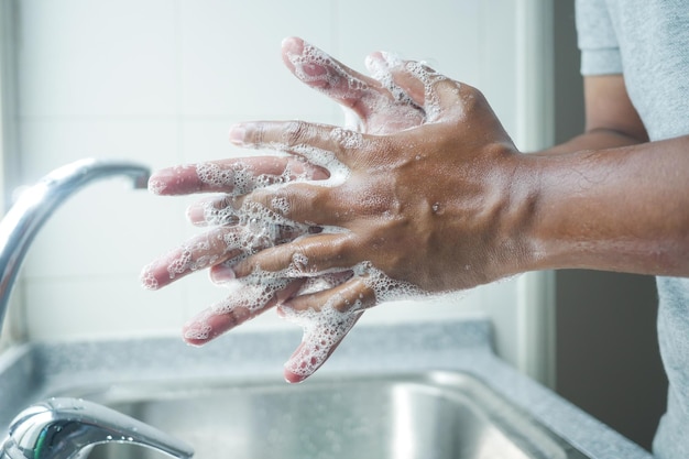 Young man washing hands with soap warm water