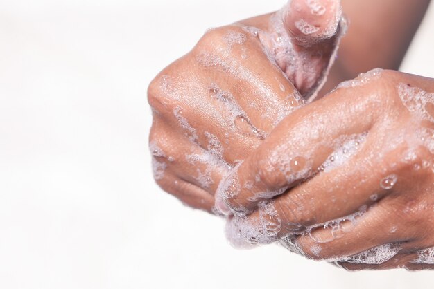 Young man washing hands with soap warm water.