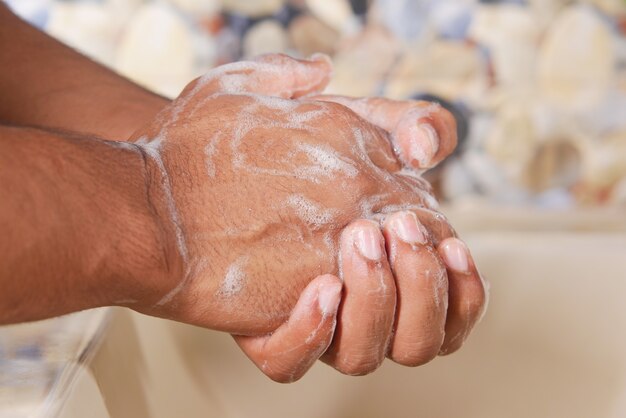 Young man washing hands with soap warm water