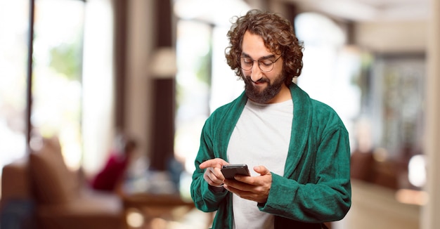 Photo young man wearing bathrobe night suit with a smart phone