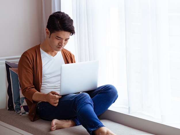 Young man wearing casual clothes and using laptop