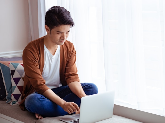 Young man wearing casual clothes and using laptop