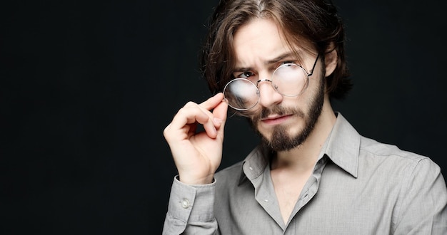 Young man wearing eyeglasses over black background Lifestyle conceptClose up