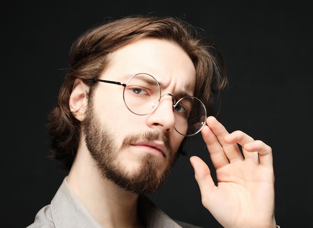 Young man wearing eyeglasses over black background Lifestyle conceptClose up