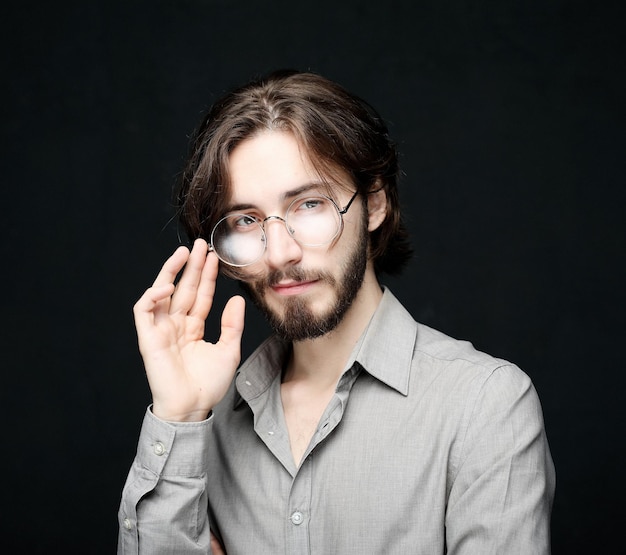 Young man wearing eyeglasses over black background Lifestyle conceptClose up