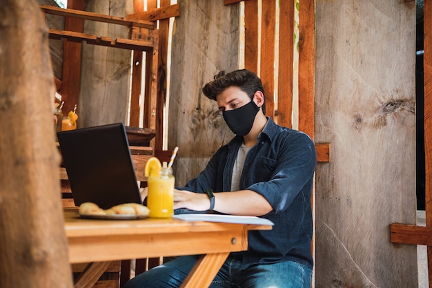 Young man wearing a protective mask in a bar