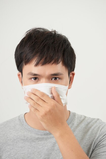 Young man wearing a protective mask isolated on white background