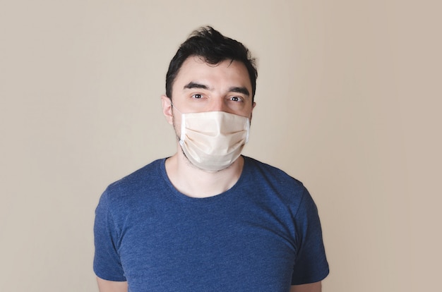 Young man wearing a protective mask on light