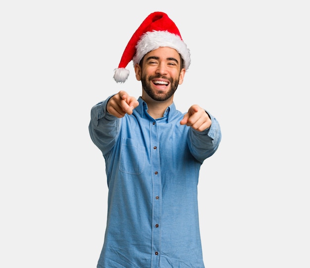 Young man wearing santa hat cheerful and smiling