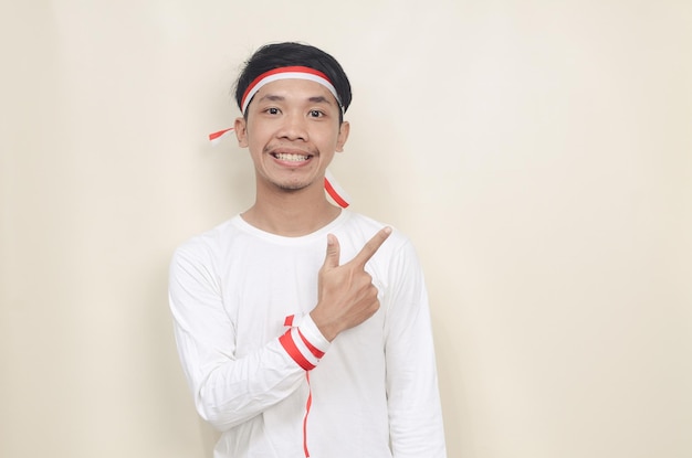 Young man wearing white tshirt smiling pointing to empty space Independence concept