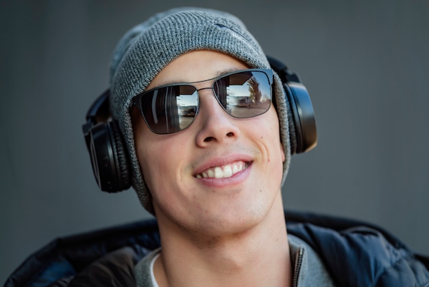 Young Man in the Winter City Streets with Headphones