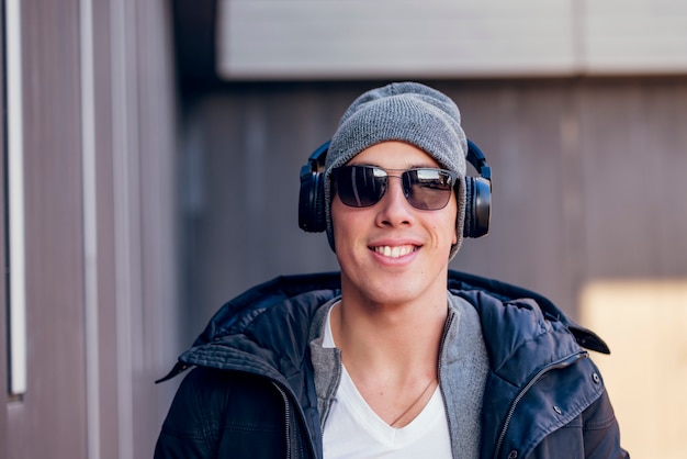 Young Man in the Winter City Streets with Headphones