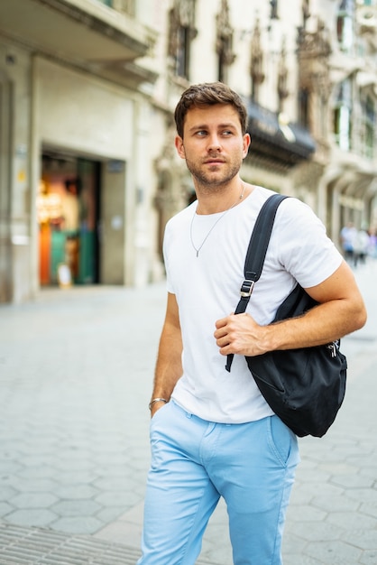 Young man with backpack in city