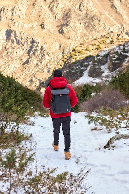 Young man with backpack see view on top mountain freedom happiness travel and vacations concept outd...