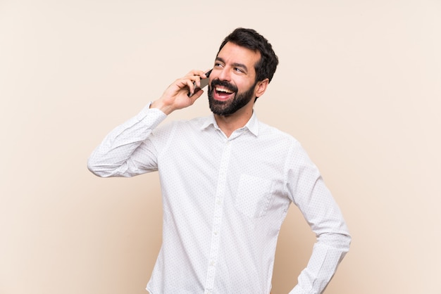 Young man with beard holding a mobile keeping a conversation with the mobile phone