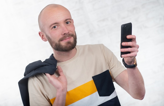 Young man with a beard talking with a smartphone