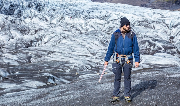 A young man with booties and hammer on the trekking of the Svinafellsjokull glacier Iceland